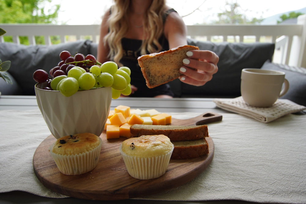 Person holding Bell's protein banana bread beside a breakfast board