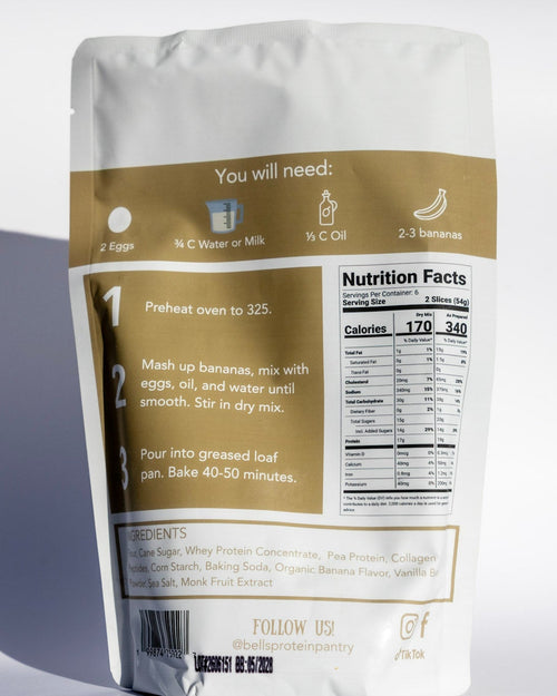A stand-up pouch of banana smoothie mix shown from the back, featuring a white and tan design with a printed nutrition facts panel and preparation instructions, photographed on a light gray background with a soft shadow.